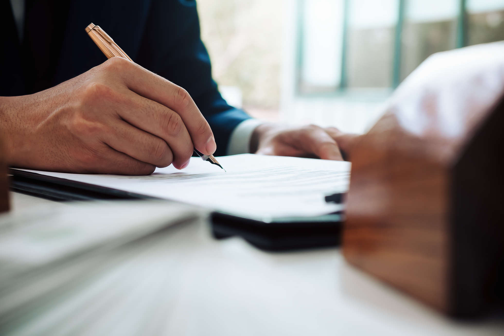 Close up of Business Person Hand Putting Signing Contract,Running Own Small Business,Have a Contract in Place to Protect It,Signing of Modest Agreements Form in Office